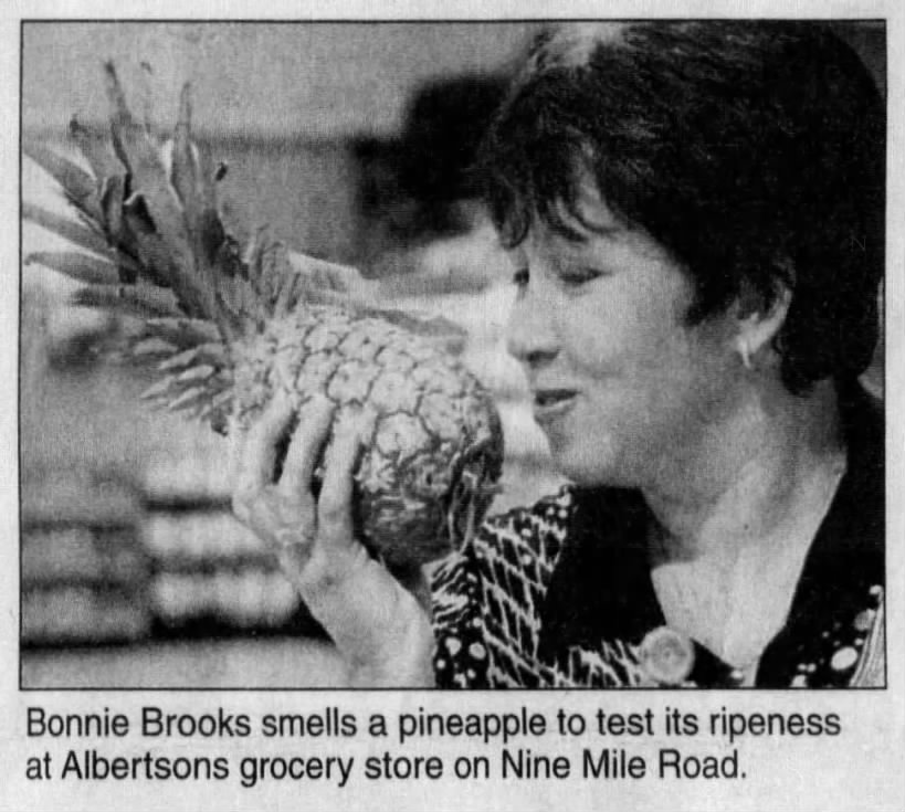 Bonnie Brooks smells a pineapple at Albertsons #4441 on W Nine Mile Road