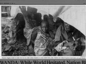 Photo of Rwandan refugees huddling for shelter under plastic sheet